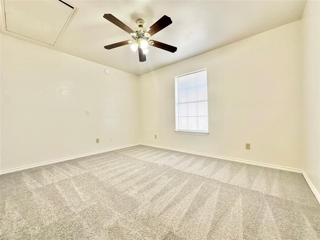 8869 Liberty Road Aubrey, TX 76227 - Photo 20 of 25 an empty room with a chandelier fan and windows