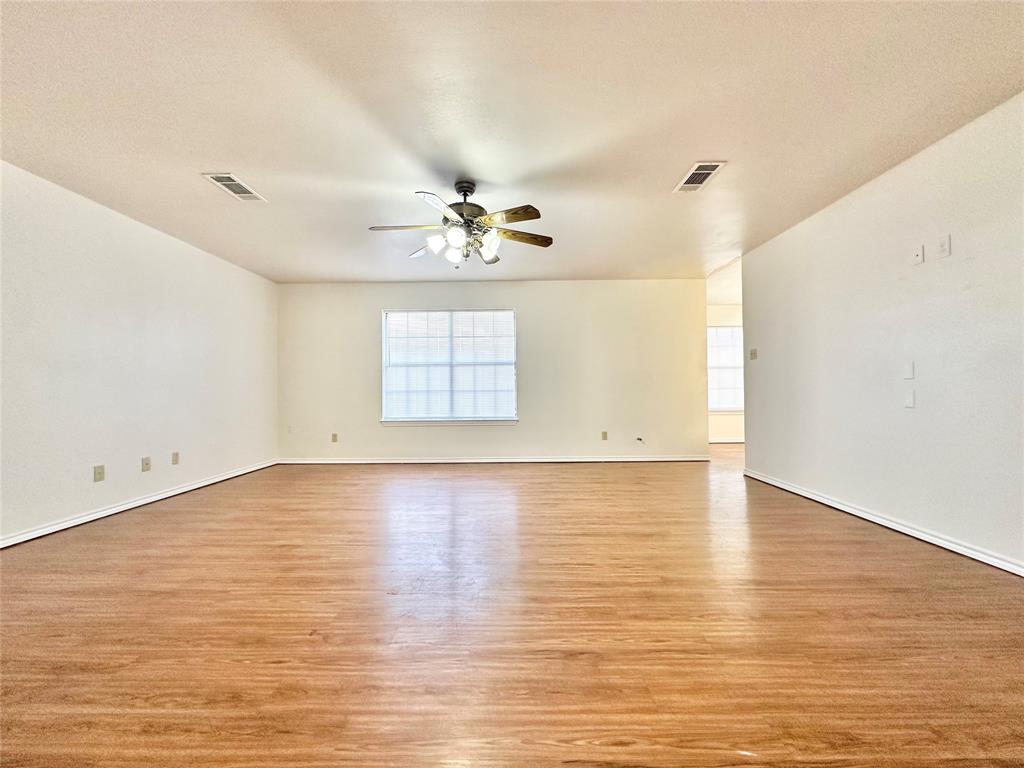 8869 Liberty Road Aubrey, TX 76227 - Photo 2 of 25 an empty room with wooden floor and windows