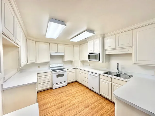a kitchen with granite countertop a sink stainless steel appliances and cabinets