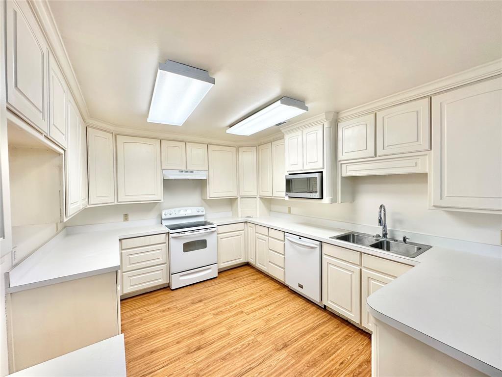 8869 Liberty Road Aubrey, TX 76227 - Photo 6 of 25 a kitchen with granite countertop a sink stainless steel appliances and cabinets