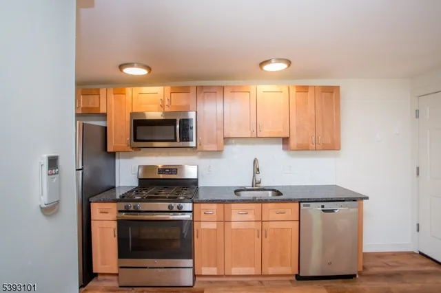 a kitchen with stainless steel appliances granite countertop a stove a sink and a microwave