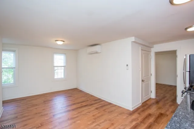 a view of a livingroom with wooden floor and window