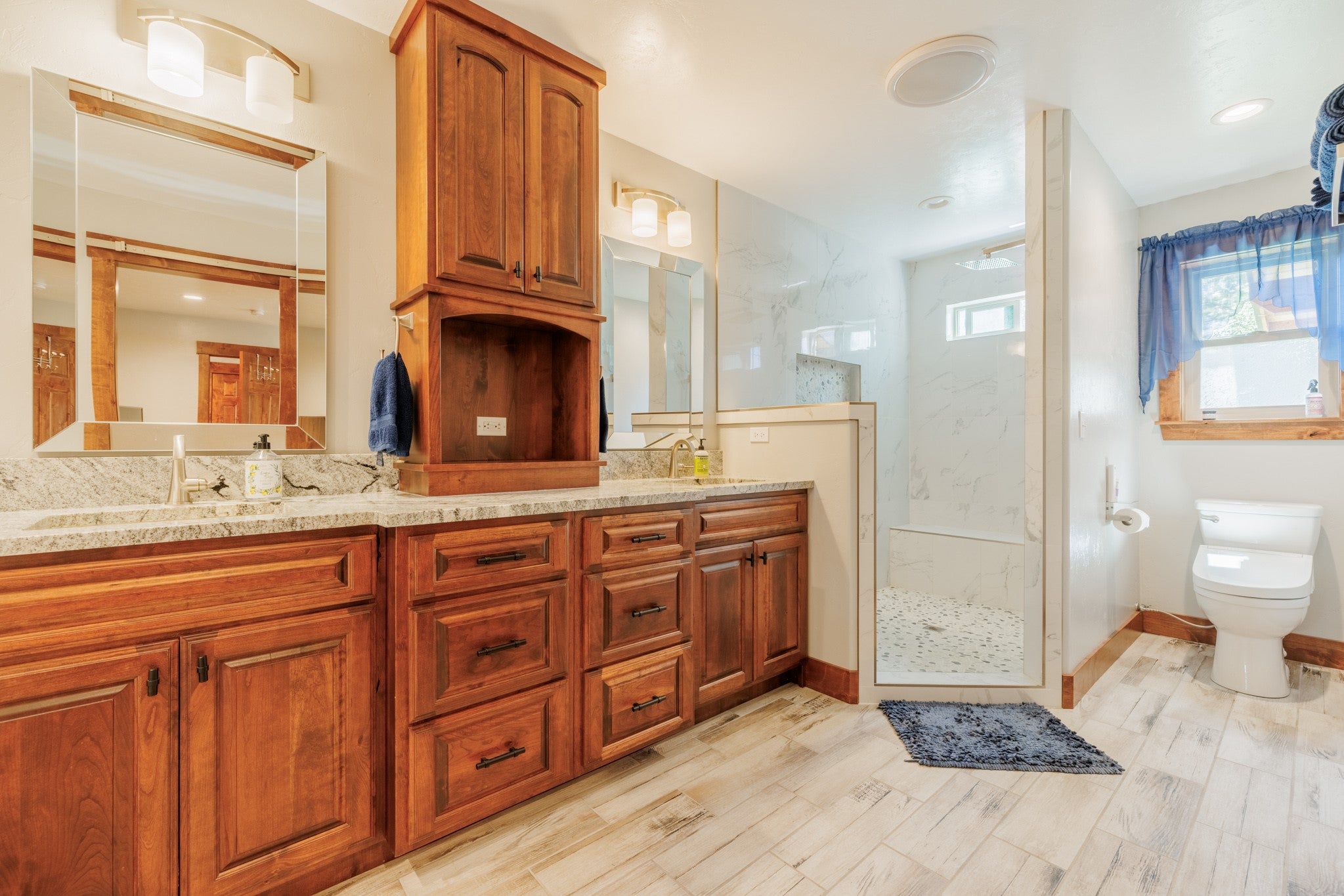 58 Gilman Road Garrison, MT 59731 - Photo 54 of 91 Full bathroom featuring a marble finish shower, double vanity, and wood finished floors