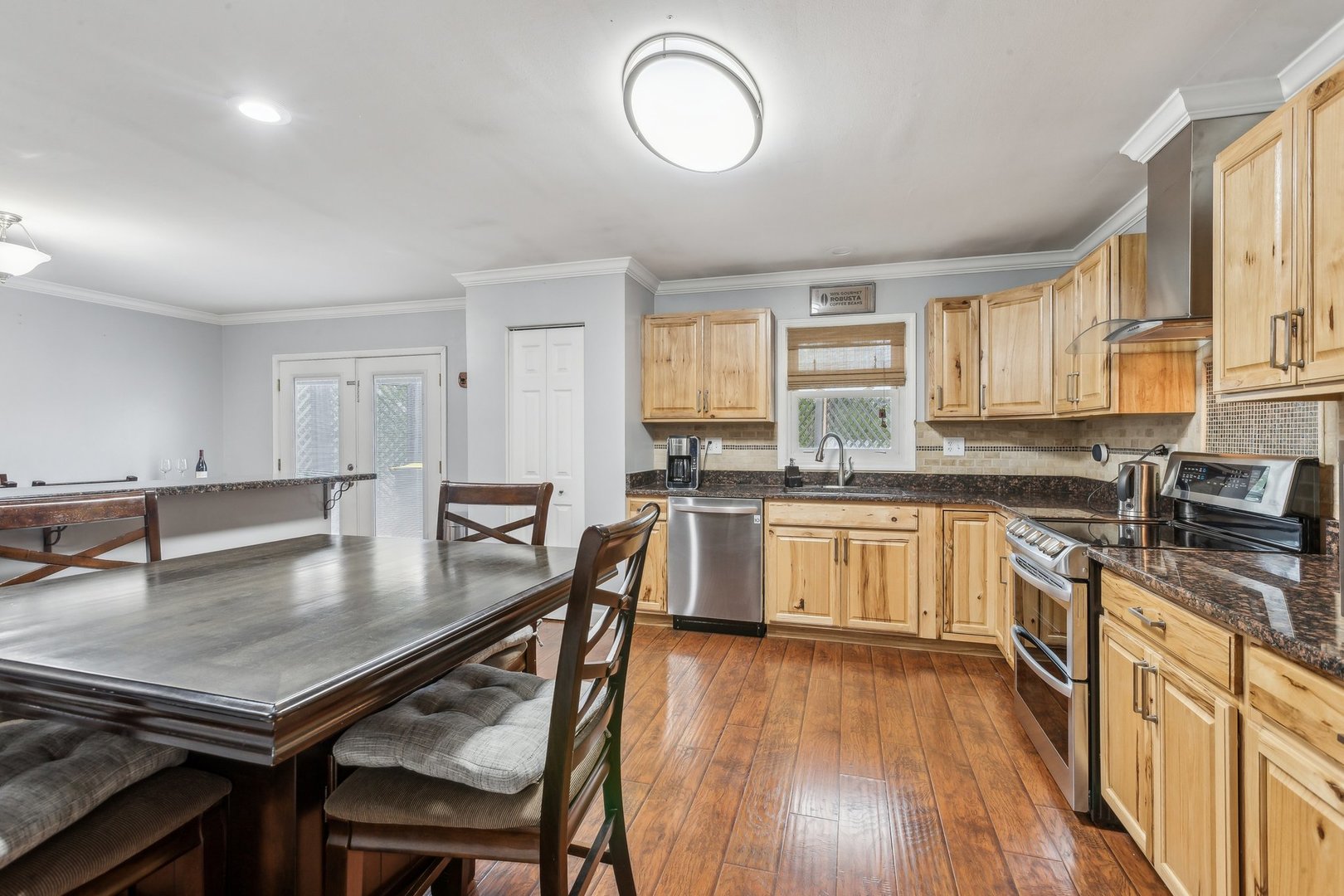 204 Oakleaf Road Lake In The Hills, IL 60156 - Photo 11 of 41 a kitchen with stainless steel appliances granite countertop a stove a sink dishwasher a microwave oven and a dining table with wooden floor