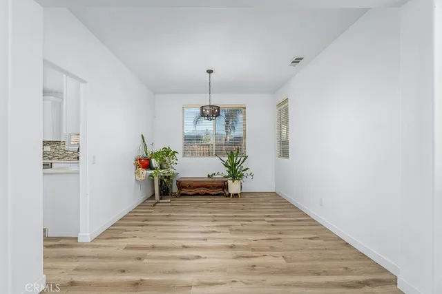 a kitchen with stainless steel appliances granite countertop a stove top oven a sink a refrigerator and white cabinets