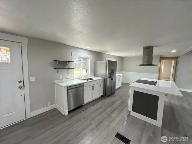 a kitchen with a sink cabinets and wooden floor