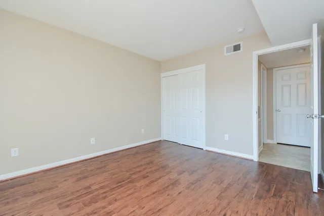 a view of an empty room with wooden floor