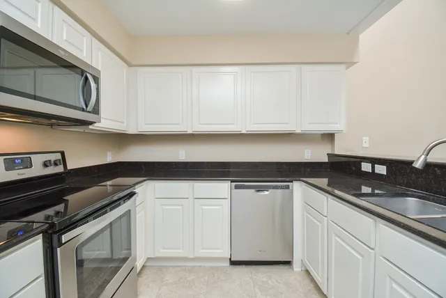 a kitchen with white cabinets and a stove top oven