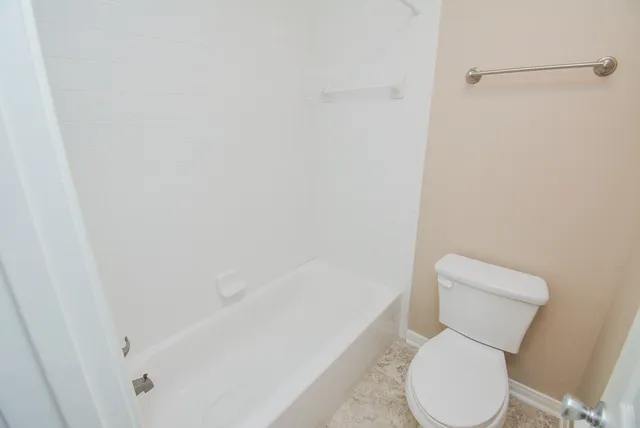 a white toilet sitting next to a white sink