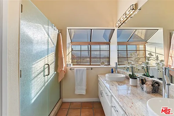a bathroom with a granite countertop sink and a large mirror