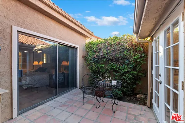 a view of backyard with a chair and potted plants