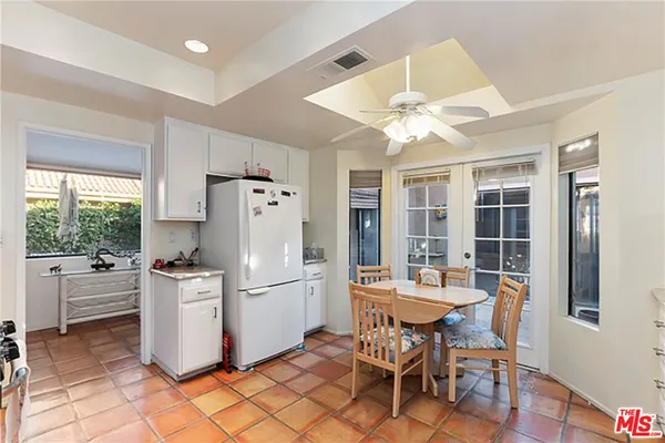 a kitchen with a dining table chairs and a refrigerator