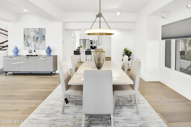 a kitchen with a sink a stove and chairs with wooden floor