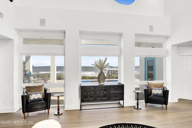 a dining room with wooden floor a chandelier a wooden table and chairs