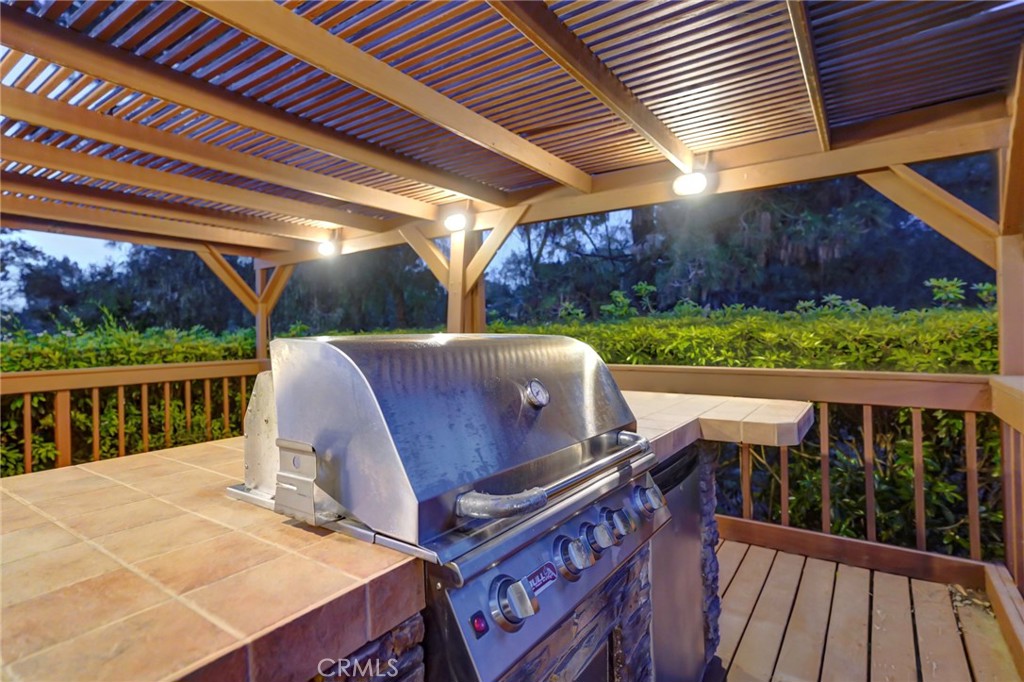 5205 Middlecrest Road Rancho Palos Verdes, CA 90275 - Photo 11 of 36 a view of a patio with table and chairs a barbeque with wooden floor and fence