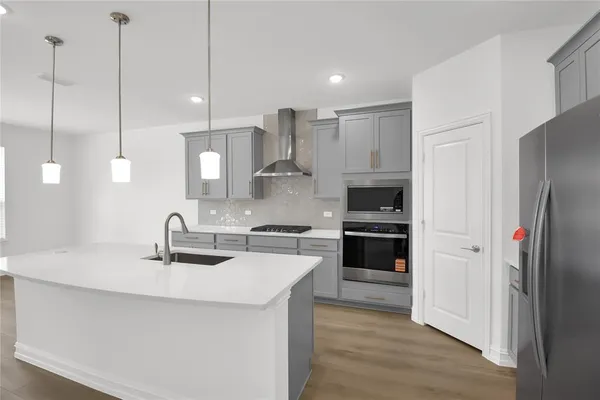 a kitchen with stainless steel appliances a refrigerator sink and stove