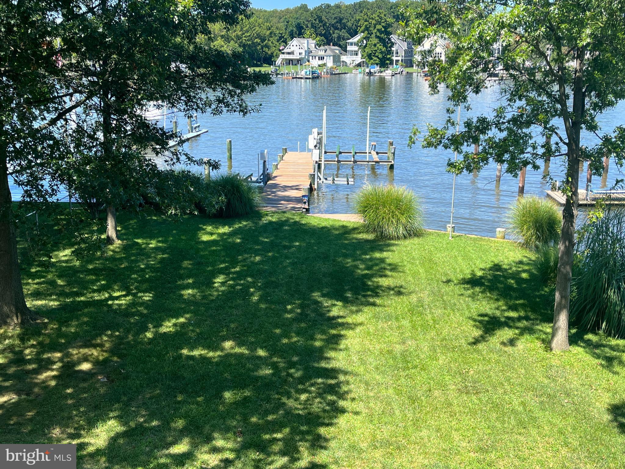 3816 Chestnut Road Baltimore, MD 21220 - Photo 1 of 27 a view of a lake with lawn chairs and a large tree