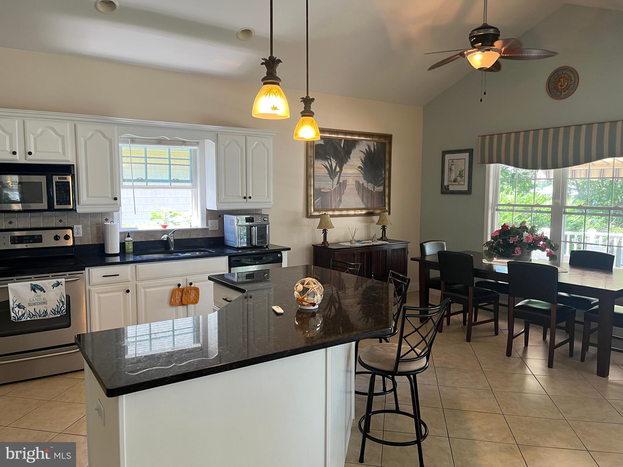 3816 Chestnut Road Baltimore, MD 21220 - Photo 13 of 27 a kitchen with stainless steel appliances granite countertop a refrigerator a sink dishwasher a dining table and chairs with wooden floor
