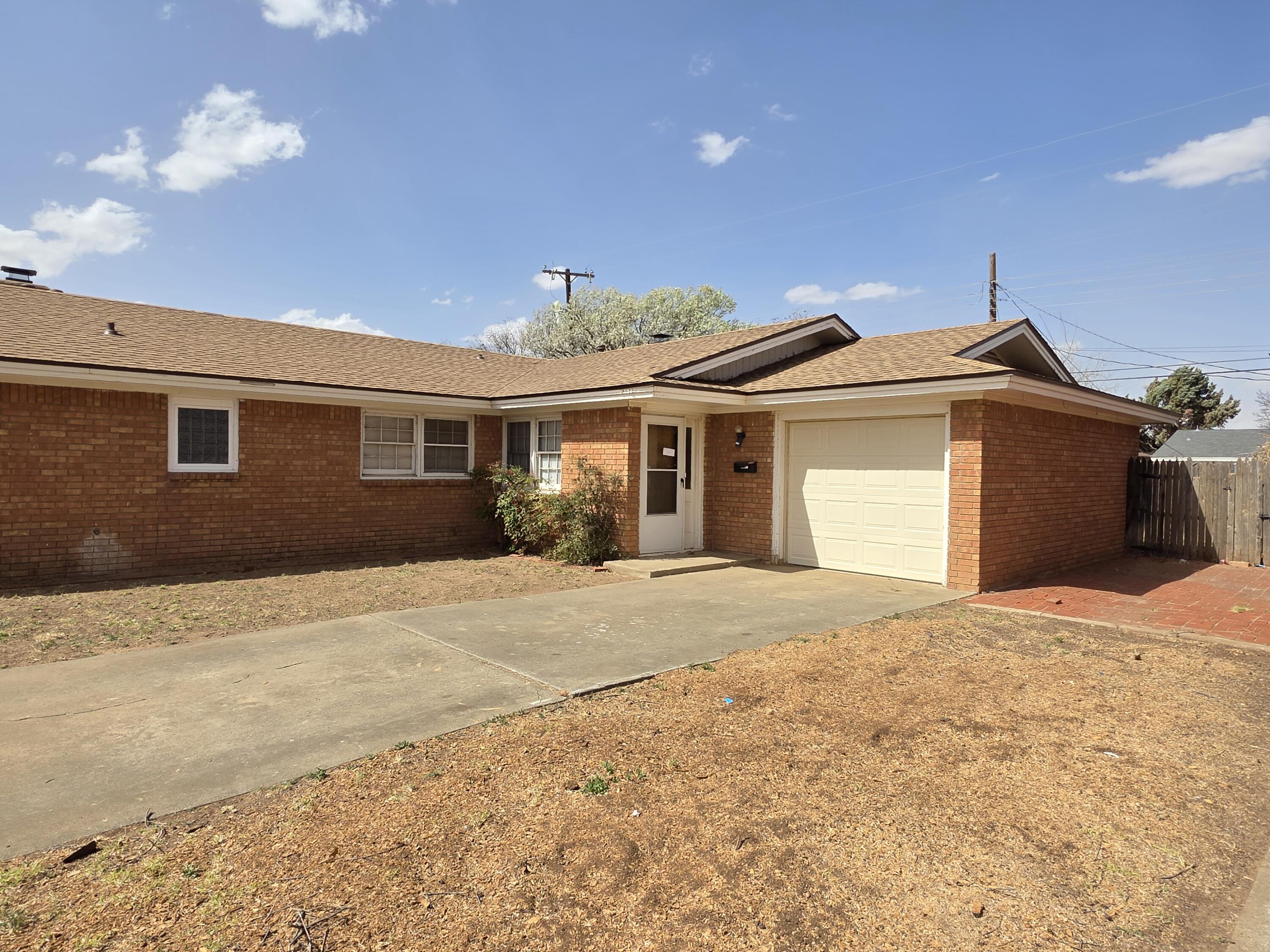 2010 54th Street Lubbock, TX 79412 - Photo 3 of 17 a front view of a house with a yard and garage