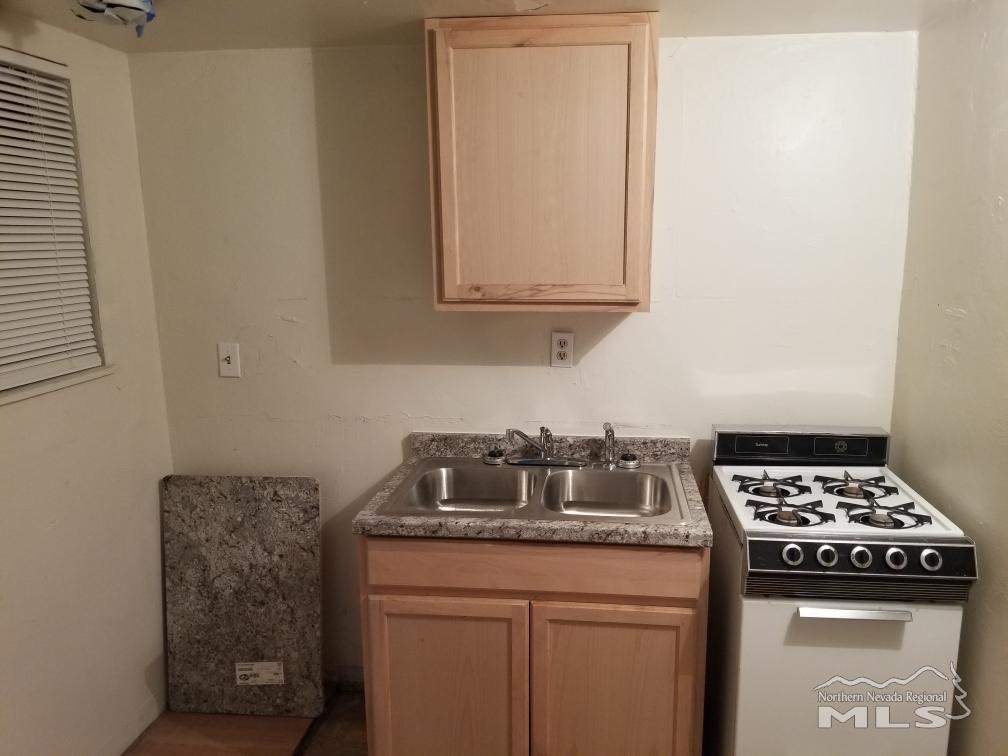 356 Gould Street Reno, NV 89502 - Photo 13 of 14 a kitchen with granite countertop a sink a stove and cabinets