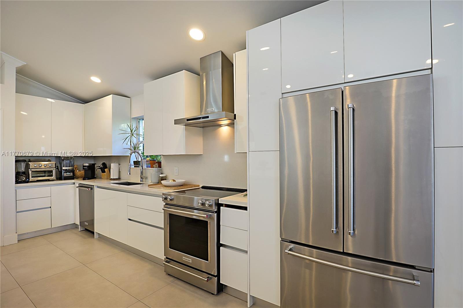 8919 Byron Avenue Surfside, FL 33154 - Photo 13 of 51 a kitchen with stainless steel appliances granite countertop a refrigerator and a stove top oven