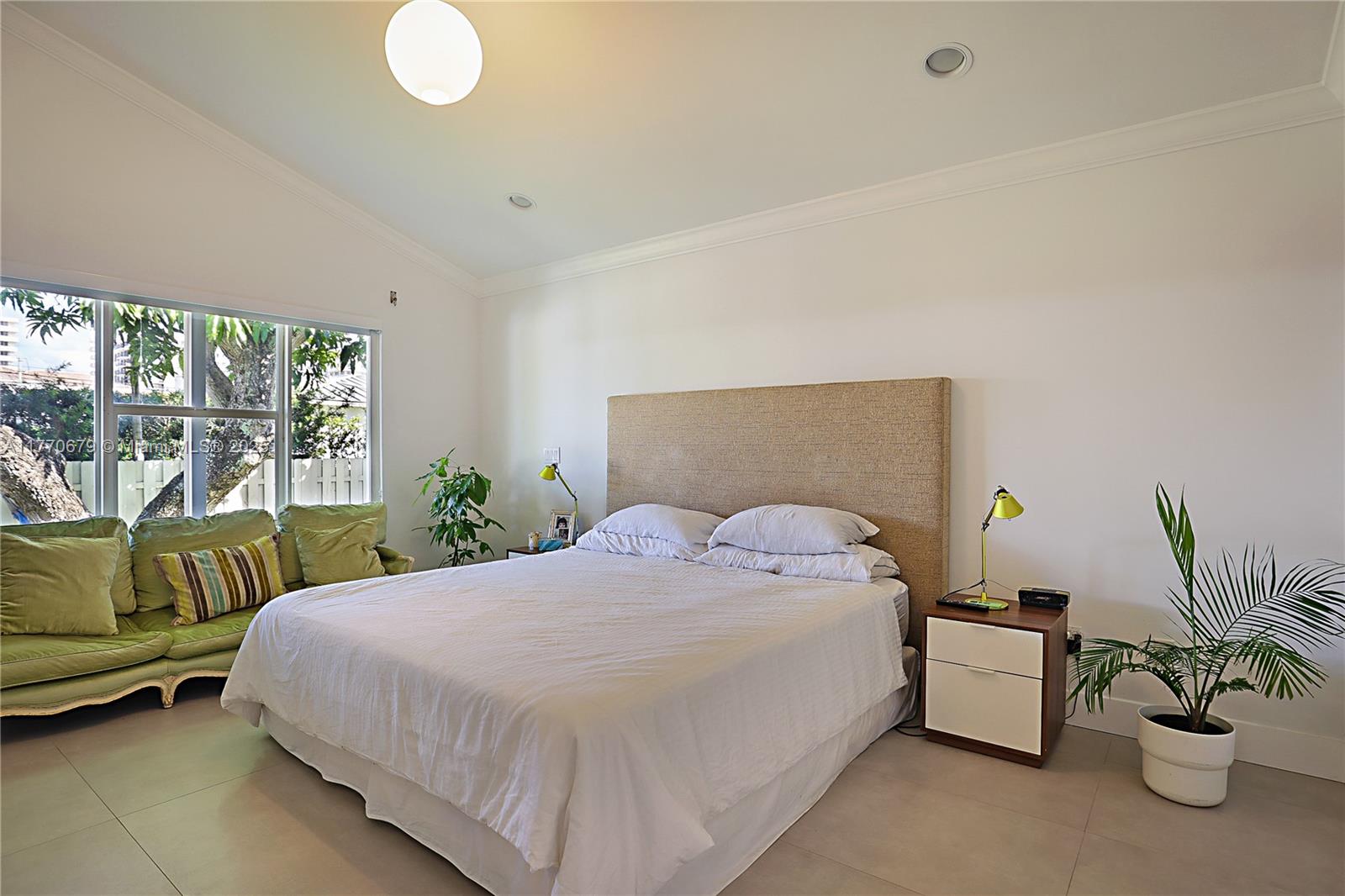 8919 Byron Avenue Surfside, FL 33154 - Photo 26 of 51 a bedroom with a bed and a large window