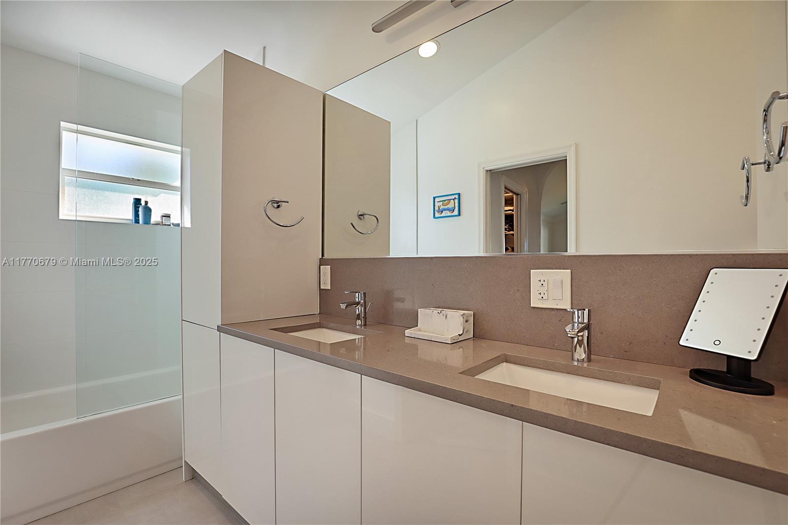 8919 Byron Avenue Surfside, FL 33154 - Photo 29 of 51 a bathroom with a granite countertop sink and a mirror