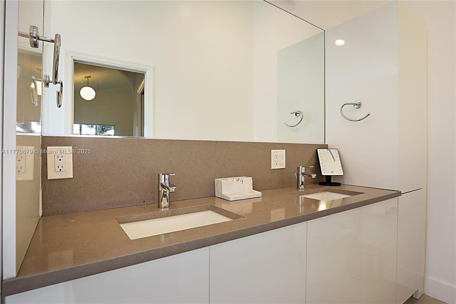 8919 Byron Avenue Surfside, FL 33154 - Photo 30 of 51 a bathroom with a sink and a mirror