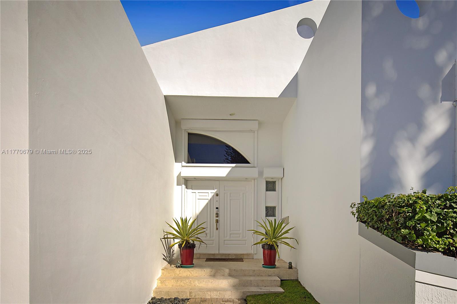 8919 Byron Avenue Surfside, FL 33154 - Photo 4 of 51 a potted plant sitting in front of a door