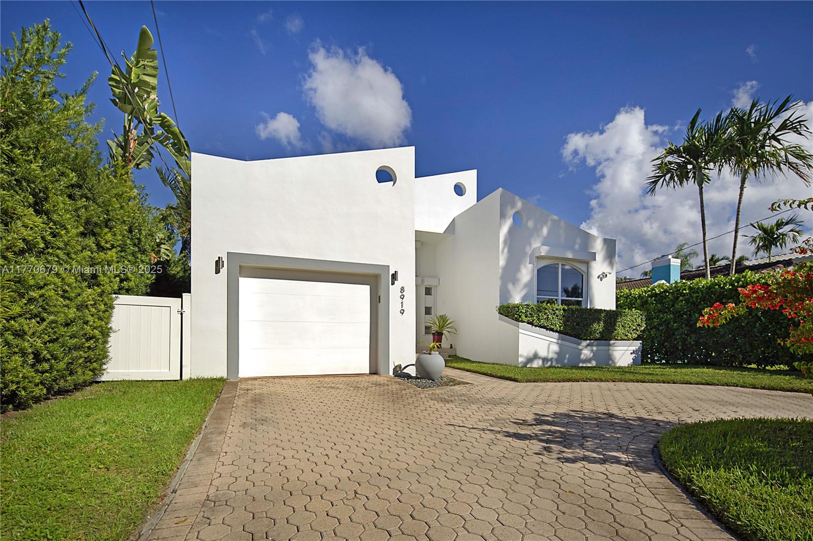 8919 Byron Avenue Surfside, FL 33154 - Photo 44 of 51 a front view of a house with a yard and garage