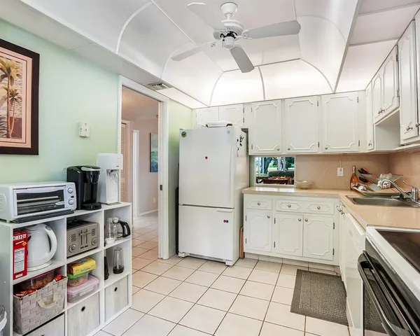a kitchen with stainless steel appliances a stove a refrigerator and white cabinets