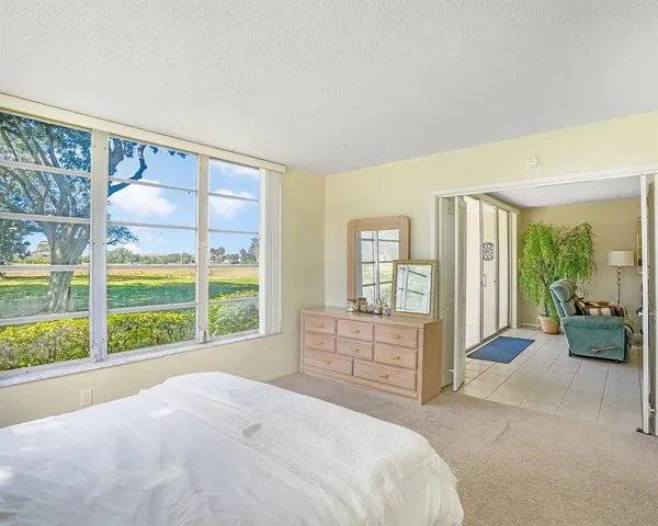 a bedroom with a bed and a large window