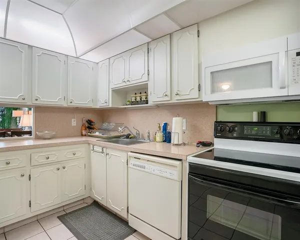 a kitchen with white cabinets appliances and a sink