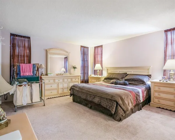 a spacious bedroom with a bed and flat screen tv