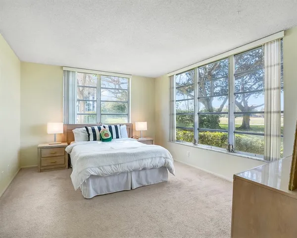 a bedroom with a large bed and a large window with outer view