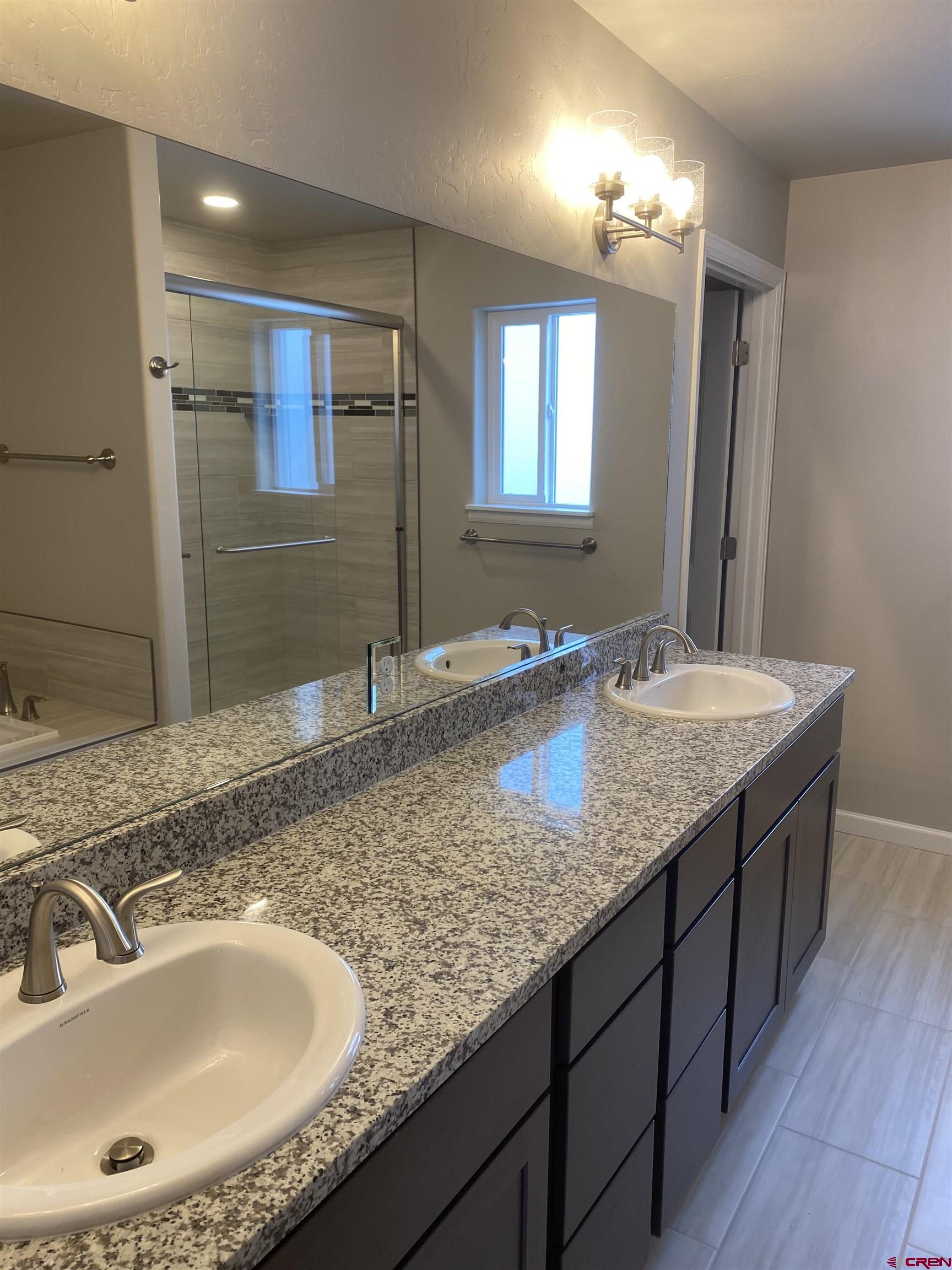 3674 Big Pines Loop Montrose, CO 81401 - Photo 14 of 19 a bathroom with a granite countertop sink and a large mirror