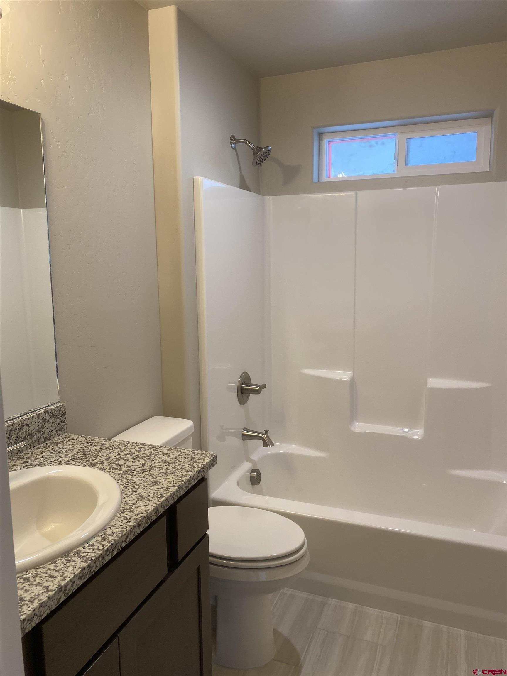 3674 Big Pines Loop Montrose, CO 81401 - Photo 9 of 19 a bathroom with a granite countertop sink a toilet and shower