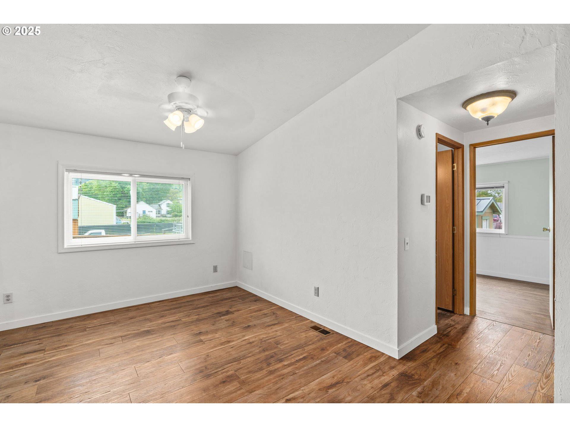 335 Division Avenue Drain, OR 97435 - Photo 13 of 25 an empty room with wooden floor and windows