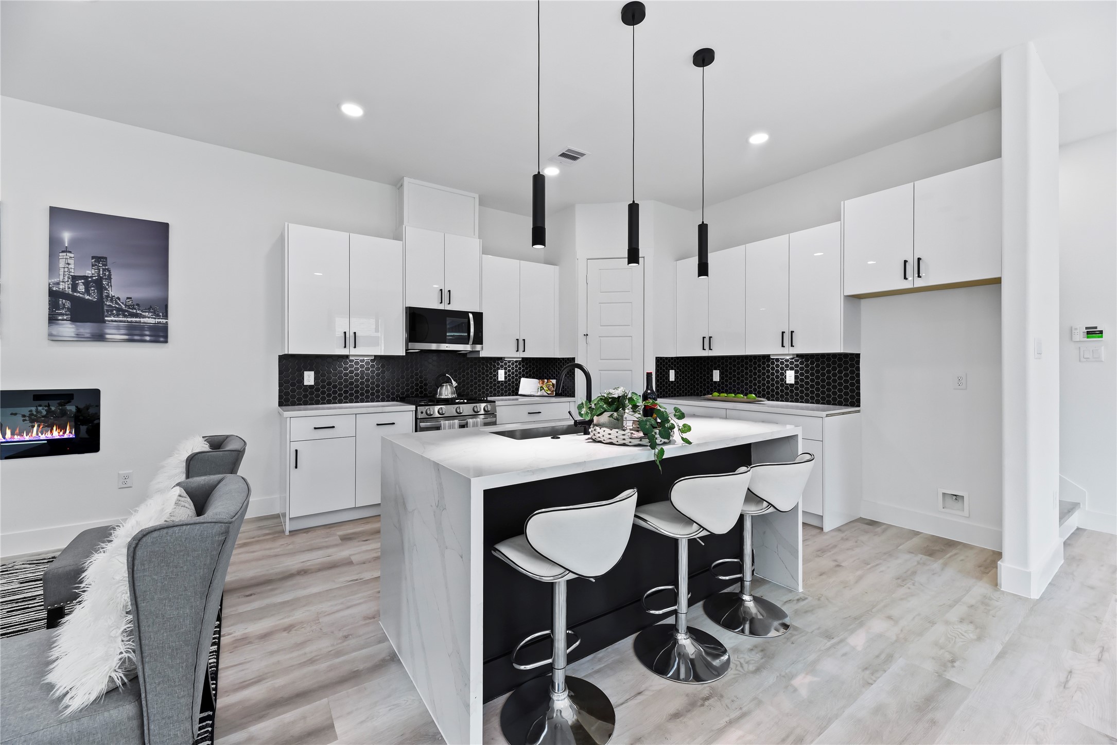 7210 England Street Houston, TX 77021 - Photo 19 of 37 a kitchen with stainless steel appliances kitchen island granite countertop a sink a stove a refrigerator and white cabinets with wooden floor