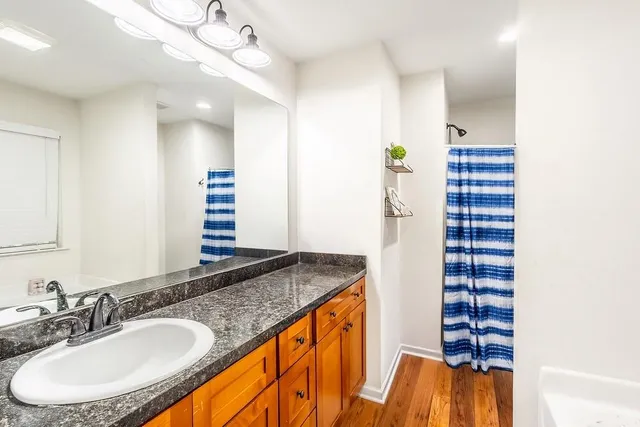 a bathroom with a granite countertop sink and a mirror