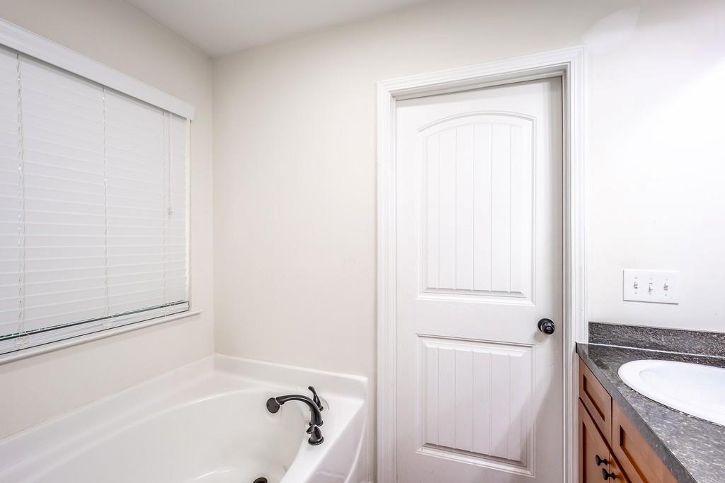 3907 Robin Court Acworth, GA 30101 - Photo 16 of 29 a bathroom with a granite countertop sink and a bathtub