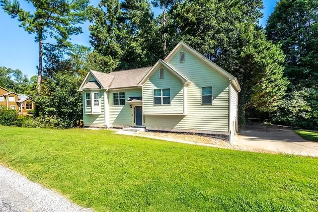 a front view of a house with yard and green space