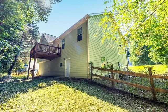 a view of a house with backyard and trees