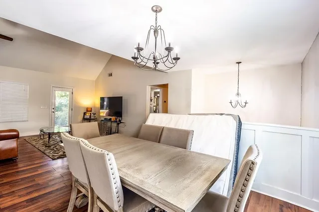 a living room with furniture a chandelier and a dining table