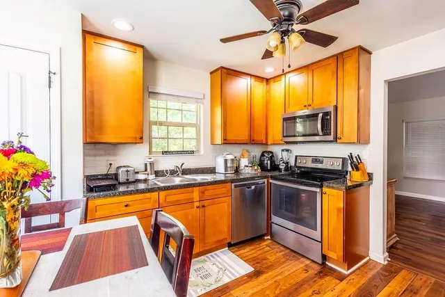 a kitchen with granite countertop a sink a counter top space appliances and cabinets