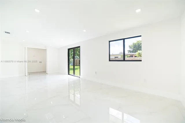 a view of a backyard with plants and a large tree