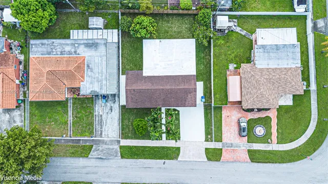 an aerial view of residential houses with outdoor space and lake view
