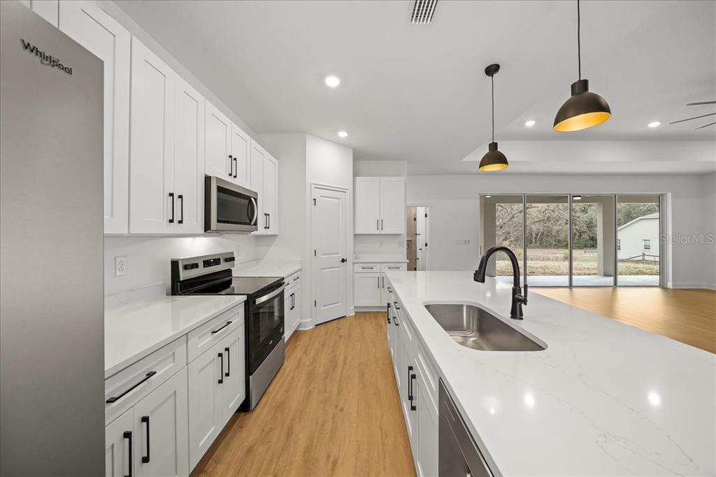 11088 Fulton Avenue Weeki Wachee, FL 34613 - Photo 13 of 63 a kitchen with sink a stove and cabinets
