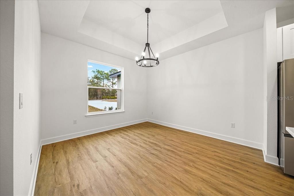 11088 Fulton Avenue Weeki Wachee, FL 34613 - Photo 16 of 63 a view of an empty room with wooden floor kitchen view and a window