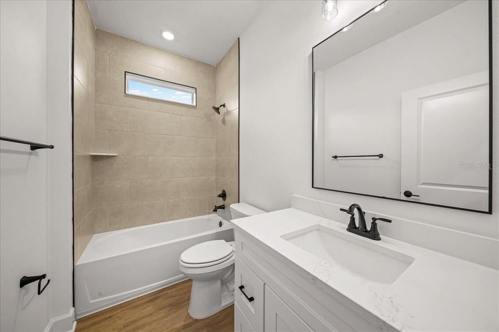 11088 Fulton Avenue Weeki Wachee, FL 34613 - Photo 36 of 63 a bathroom with a granite countertop sink toilet and shower